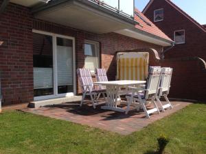 a patio with a table and chairs on a lawn at kleiner-Fiete in Wittdün +12 photos