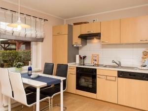 a kitchen with a table and a sink and a stove at kleiner-Fiete in Wittdün