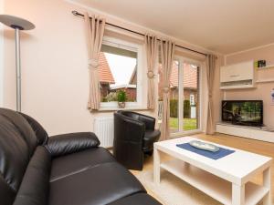 a living room with a black leather couch and a table at kleiner-Fiete in Wittdün