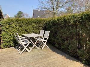 two chairs and a table on a wooden deck at grosser-Fiete in Wittdün