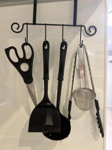 a bunch of kitchen utensils hanging on a rack at ドリームホテル住吉 in Sumiyoshi