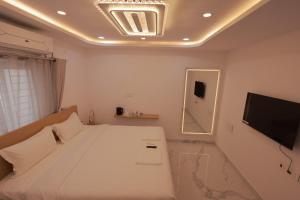 a bedroom with a bed and a mirror and a television at Hotel Vibrama in Tirupati