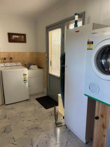 a laundry room with a washer and dryer at Foundry Cottages in Rutherglen