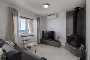a living room with a couch and a fireplace at Seafront Escape - 4BR Beachfront Villa for 8 in Šibuljina