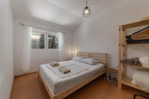 a white bedroom with a bed and a window at Seafront Escape - 4BR Beachfront Villa for 8 in Šibuljina