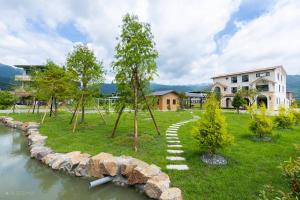a stone path in a park next to a river at 50 Lan House in Yilan City