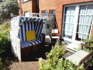 a wicker chair sitting on the porch of a house at Muschel in Wittdün +9 photos