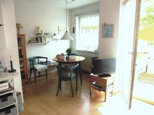 a living room with a table and a television at Muschel in Wittdün