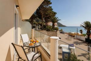 ein Balkon mit Tisch und Stühlen und dem Meer in der Unterkunft Azure Mare Studios in Agios Georgios Pagon