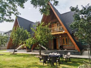 a house with a table and chairs in front of it at French Woods Cottages in Srinagar +26 photos