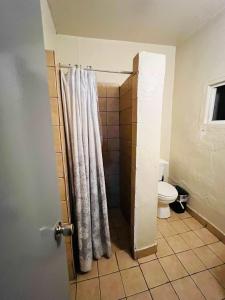 a bathroom with a shower curtain and a toilet at room #2 Rancho Meling in Camalú