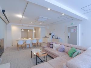 a living room with a couch and a table at INOVE VILLA OSAKA -120m2 , 7 Double Beds , 2 BR , 2 Bath , Easy Access to Umeda , Kyoto ーPerfect for Families & Groupsー in Osaka