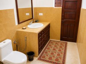 a bathroom with a sink and a toilet and a mirror at Killa Bhawan Lodge in Jaisalmer +20 photos