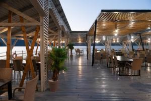 a restaurant on the beach with tables and chairs at Chalet Port Bicaz in Bicaz