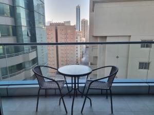 a table and two chairs on a balcony with a view at Sea View Apartment in Era View in Manama