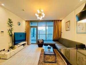 a living room with a couch and a tv at Sea View Apartment in Era View in Manama