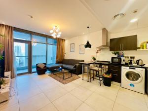 a kitchen and living room with a couch and a dishwasher at Sea View Apartment in Era View in Manama +7 photos