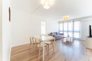 a white living room with a table and a couch at A350 Suites - Appartement climatisé, 2 chambres in Colomiers