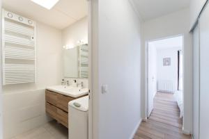 a white bathroom with a tub and a sink at A350 Suites - Appartement climatisé, 2 chambres in Colomiers +13 photos