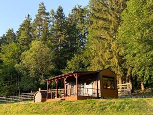 a small building in a field with trees at Čiles in Kostolec