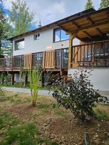 a house with a deck on the side of it at PineHills in Mărişel
