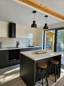a kitchen with a large island with two bar stools at PineHills in Mărişel