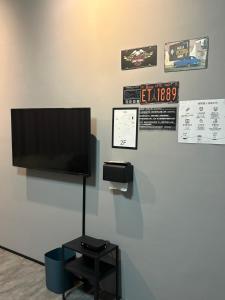 a flat screen tv on a wall with a table at 鄉間旅人 自助入住 in Ta-pu-mei +15 photos