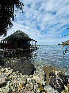 a building on the water with rocks in front at Faimano Lodge & Car in HUH