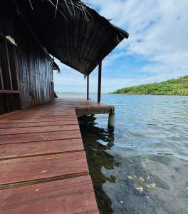 a wooden dock with a hut on the water at Faimano Lodge & Car in HUH