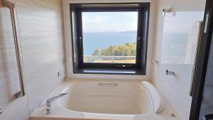 a bathroom with a sink and a window at ジローズガーデン in Ishinomaki