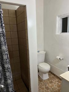 a bathroom with a toilet and a shower at Rancho Meling in Camalú