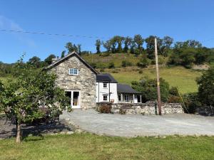a stone house with a hill in the background at Peniarth Ganol in Tywyn