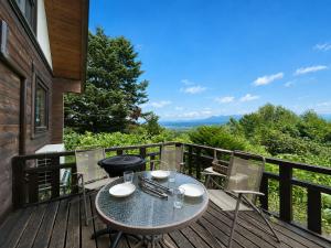 a patio with a table and chairs on a deck at Best View in Nakafurano
