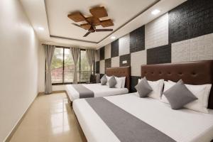 a bedroom with two beds and a ceiling fan at MogPrach Boutique in Calangute +7 photos