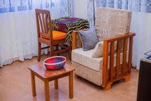 a living room with chairs and a bowl on a table at CAM Apartments in Dodoma