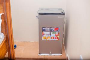 a refrigerator is sitting on the floor in a room at CAM Apartments in Dodoma