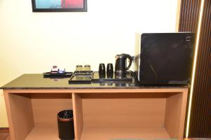 a desk with a microwave and a television on it at HOTEL THIRD EYE bY RAMANA TOWERS in Tiruvannāmalai