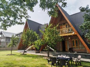 an external view of a house with tables and chairs at French Woods Cottages in Srinagar