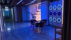 a room with two chairs and a table with blue lights at Jianpuke Space Capsule Backpacker Hostel in Sihanoukville