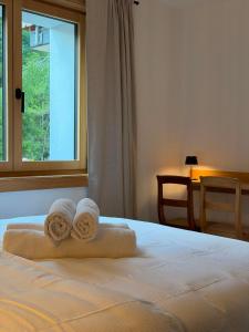 a bedroom with a bed with towels on it at Chalet du Lac in Charmey