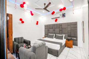 a bedroom with a bed and two chairs and red balloons at Hotel Amar Raja in Kurukshetra +1 photo