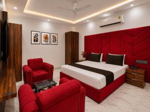 a bedroom with a red bed and a red couch at Hotel Amar Raja in Kurukshetra