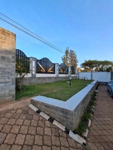 a house with a stone wall and a yard at Kigali Alba Home in Kigali