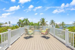 a deck with chairs and a table and the ocean at Murmond- Captiva Home in Captiva