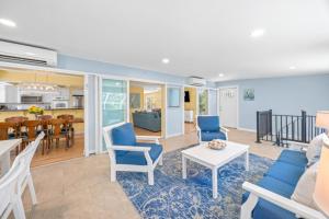 a living room with blue chairs and a table at Murmond- Captiva Home in Captiva