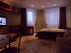 レウトフにあるApartment Yubileynyy prospekt 63のベッド、ソファ、テレビが備わるホテルルームです。