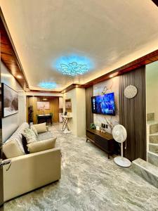 a living room with a couch and a flat screen tv at Casa de Villanueva in Davao City