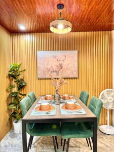 a dining room with a table and green chairs at Casa de Villanueva in Davao City +9 photos
