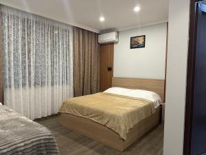 a small bedroom with a bed and a window at Luso in Batumi