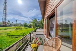 a balcony with a view of a rice field at The Solas Villa Ubud in Ubud